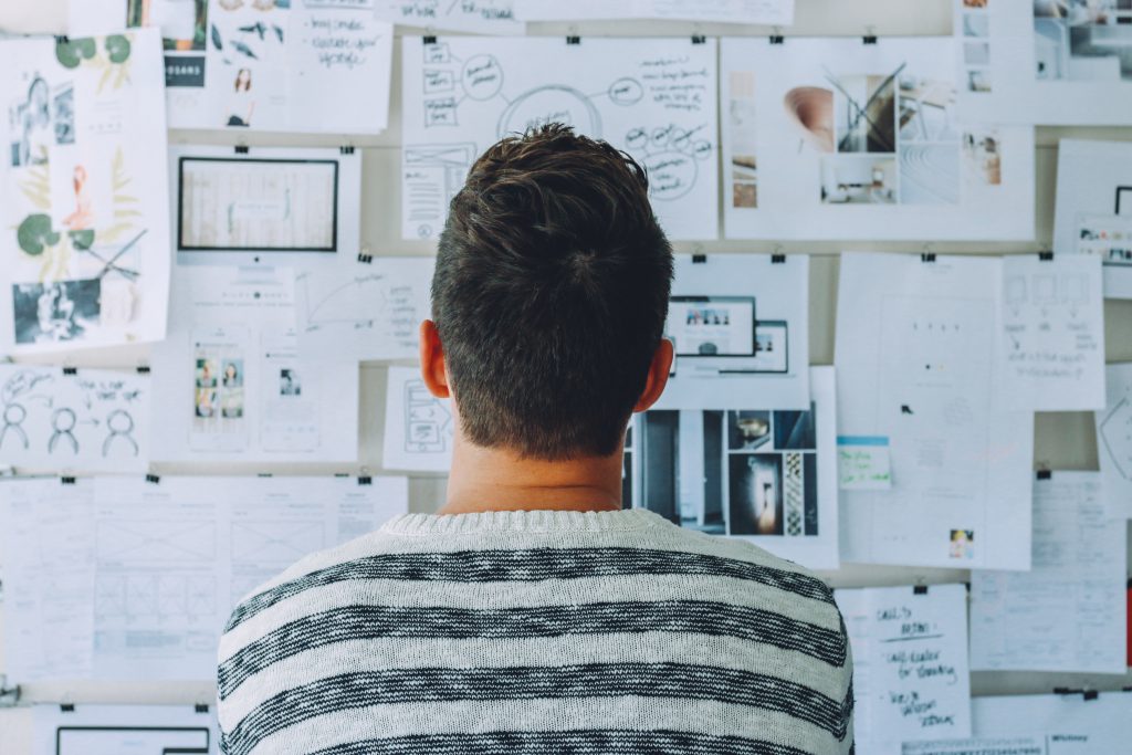 Young man looking intently at a wall with charts and graphs