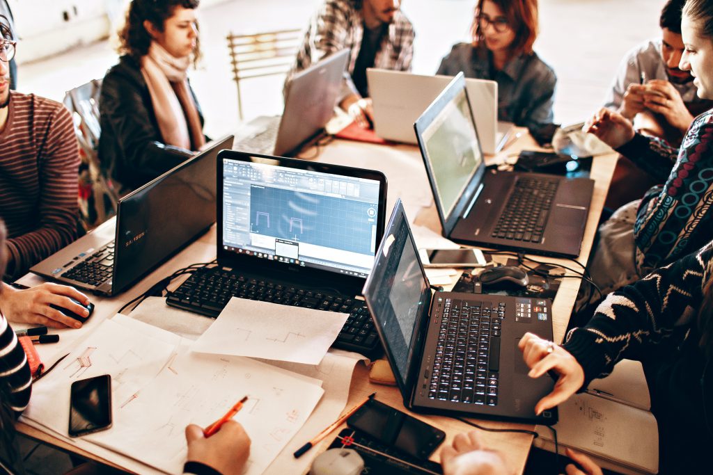 Startup employees sitting around a table with laptops